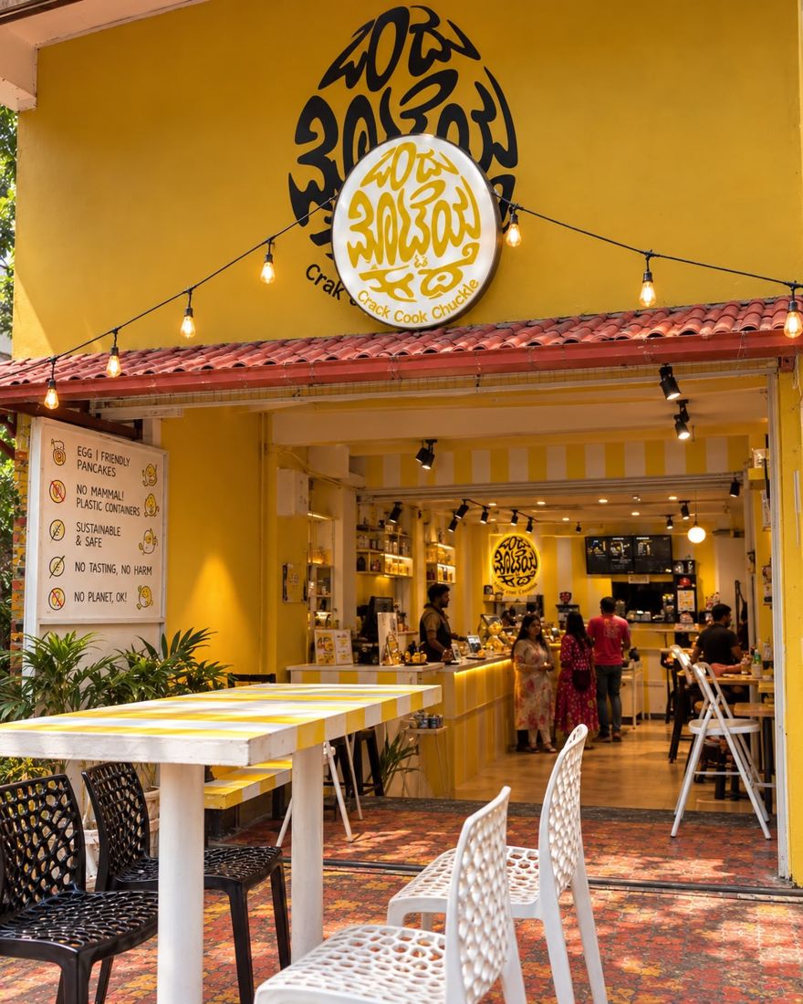 The OMK RR Nagar outlet: yellow walls, open kitchen and outdoor seating